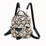 Una pequeña mochila de moda en imitación de piel de serpiente. Este práctico bolsito le permitirá llevar todo lo que necesite para el día. Llévela colgada del hombro o como mochila, seguro que dará el toque final a su estilo.