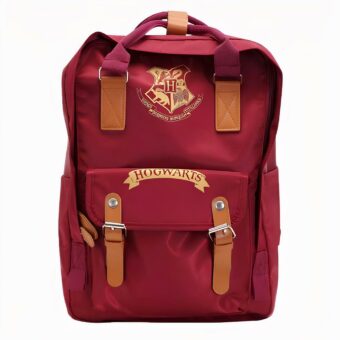Mochila escolar rectangular roja con una altura mayor que la anchura. Correas y asa marrones. Logotipo estilo escudo y escritura en el bolsillo inferior en amarillo.