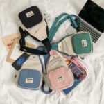 Mini mochila de lona para niña estilo bandolera sobre una cama