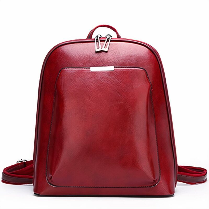 Pequeña mochila vintage en polipiel roja lisa con fondo blanco