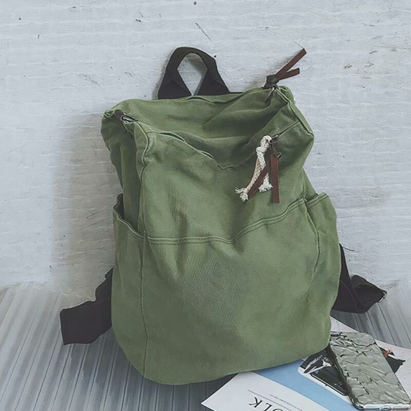 Mochila de viaje de lona verde con pared gris