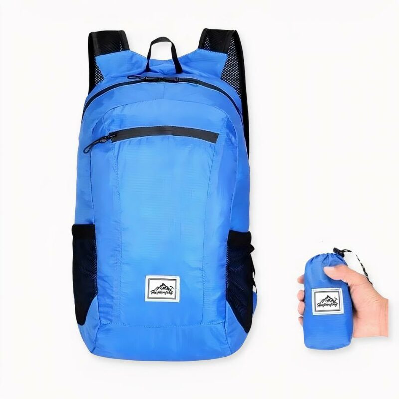 Mochila de esquí ligera y plegable en azul sobre fondo gris claro.