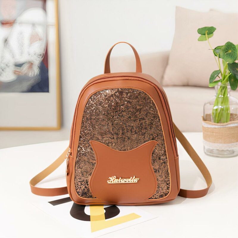 Mini mochila de lentejuelas marrones para niñas con un fondo de mesa blanco, un sofá beige y un marco