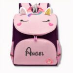 Mochila infantil morada y rosa con diseño de unicornio y Ángel escrito sobre fondo gris claro