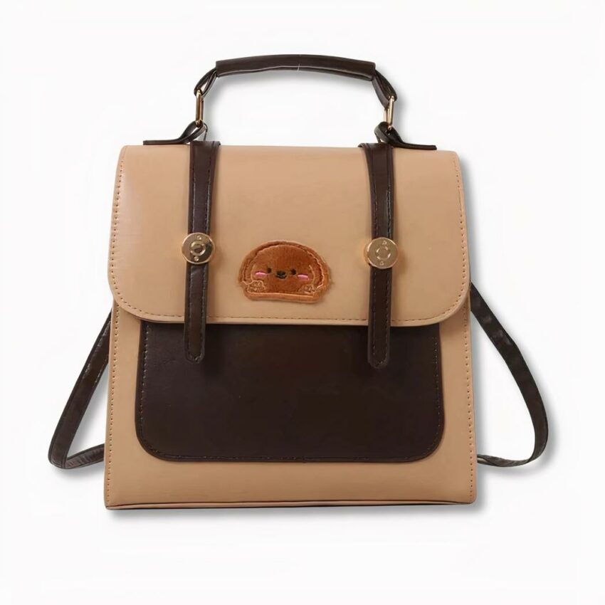 Mochila escolar marrón y beige con insignia de cara de perro en la parte delantera, sobre fondo gris claro