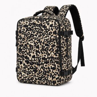 Un sac à dos voyage femme imprimé léopard grande capacité cabine posé sur fond blanc, avec plusieurs poches, des bretelles noires et un motif léopard beige et noir.