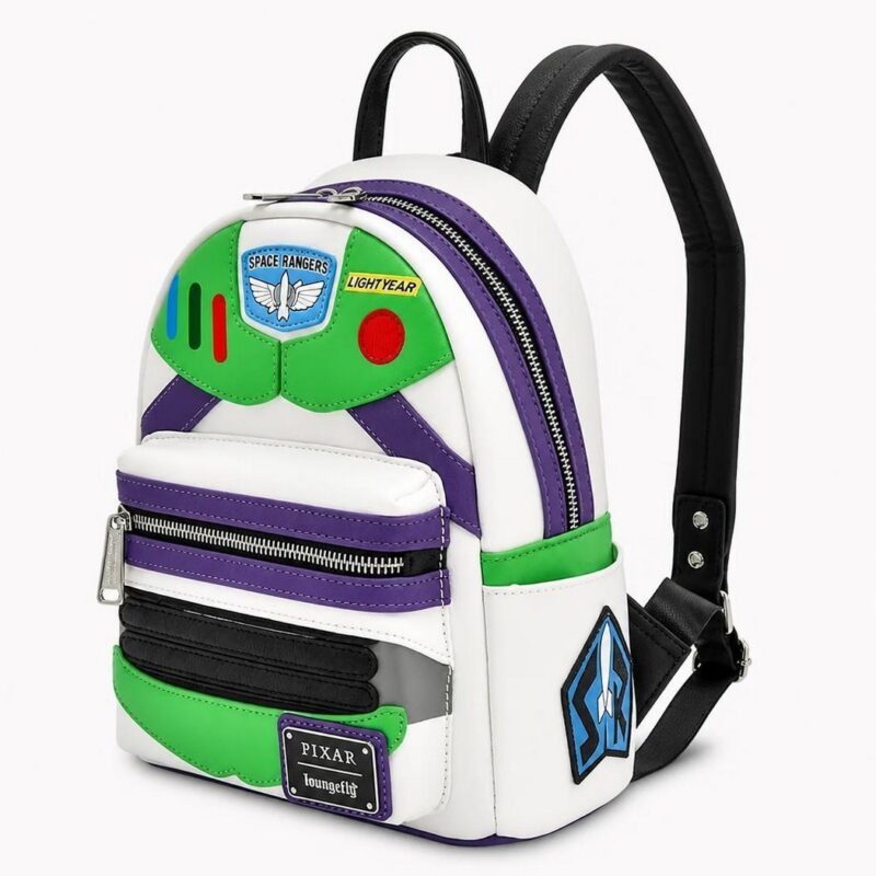 IMG_07_07_mochila_toy_story_impresa_del_heroe_buzz_1.jpg Un sac à dos Toy Story imprimé du héros Buzz, blanc, vert et violet, avec des détails spatiaux et des bretelles noires, posé sur fond blanc.